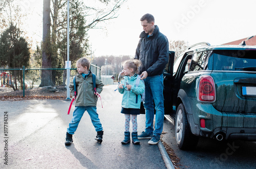 father dropping his kids off at school in the morning