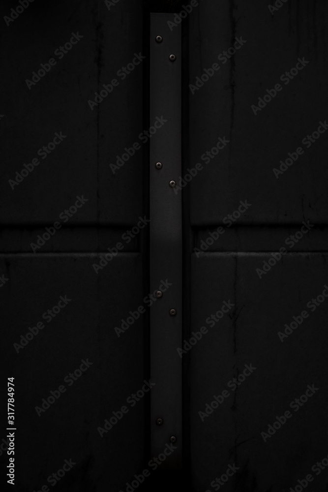 Black metal wall texture background. Modern building wall from metal plates with nails. Close up with copy space for design Black metal wall texture background. Modern building wall from metal plates with nails. Close up with copy space for design