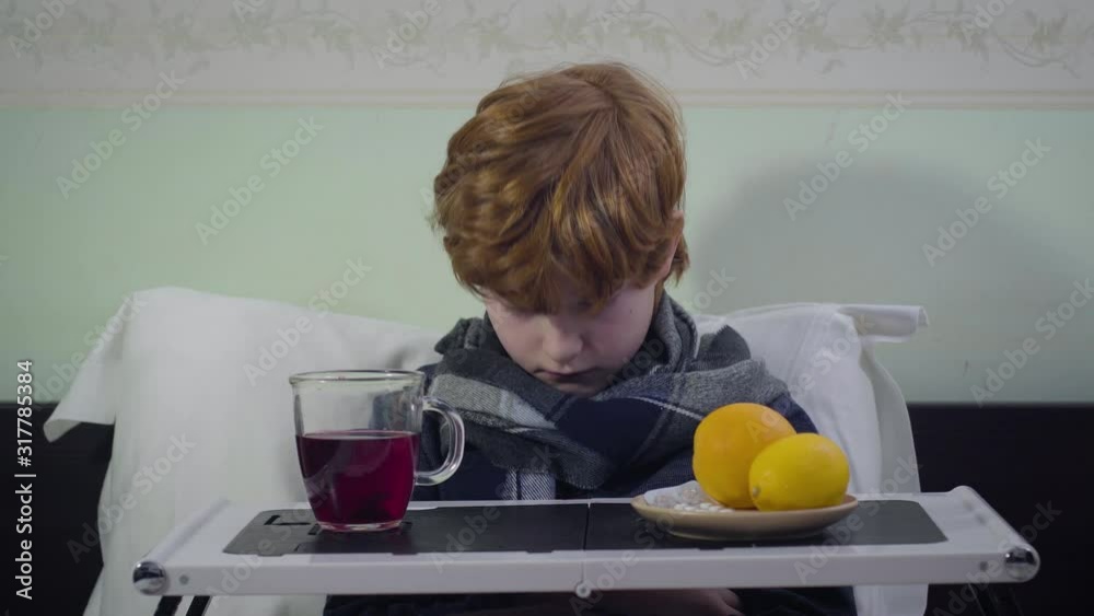 Headshot of redhead Caucasian boy rising head and looking at camera. Dissatisfied ill kid sitting in bed at home. Healthcare, sickness, medicine. Headshot of redhead Caucasian boy rising head and looking at camera. Dissatisfied ill kid sitting in bed at home. Healthcare, sickness, medicine.