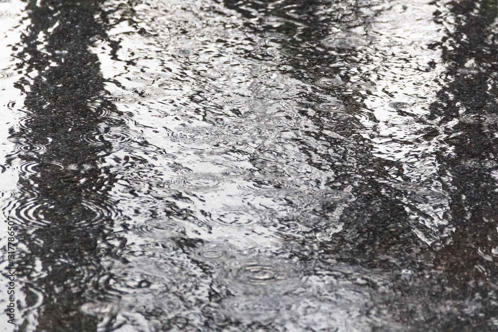 rain, raindrops on the pavement in a spray of water and the reflection of light in water rain, raindrops on the pavement in a spray of water and the reflection of light in water