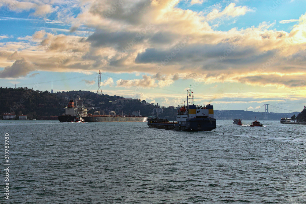 Scenic landscape view of The Bosporus (Bosphorus or Strait of Istanbul) on a cloudy winter day. The Bosporus Strait with sea traffic, ships and boats. Travel and tourism concept. Istanbul, Turkey