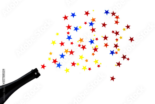 Multi-colored star confetti from a bottle of champagne. Concept for party fountain from a bottle. White background.