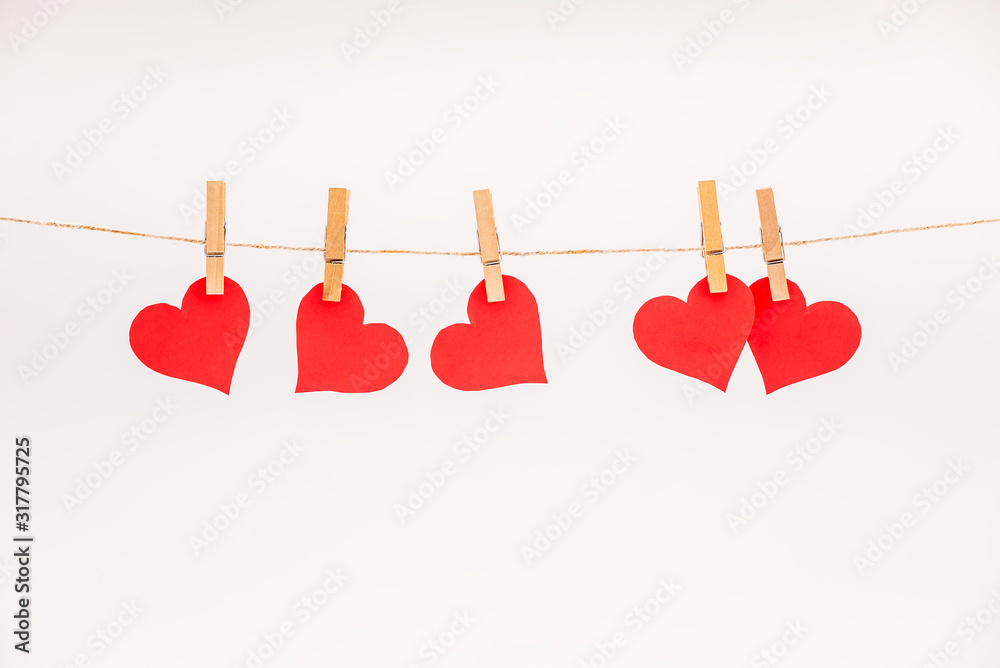 Cup of Coffee grains with heart shaped chocolate cookies and red paper hearts on pink pastel background. Clothes pegs and red paper hearts on rope. Valentines day concept Cup of Coffee grains with heart shaped chocolate cookies and red paper hearts on pink pastel background. Clothes pegs and red paper hearts on rope. Valentines day concept