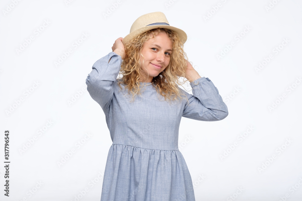 Cute young caucasian lady in blue dress with hat on summer vacation, summer smiling woman in studio Cute young caucasian lady in blue dress with hat on summer vacation, summer smiling woman in studio