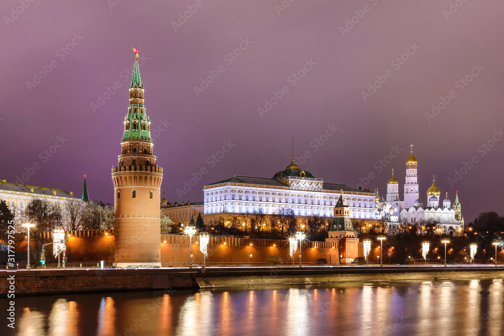 Illuminated Moscow Kremlin with Grand Kremlin Palace the government residence of president of Russia. View from the embankment of Moskva river. Evening urban landscape in the blue hour