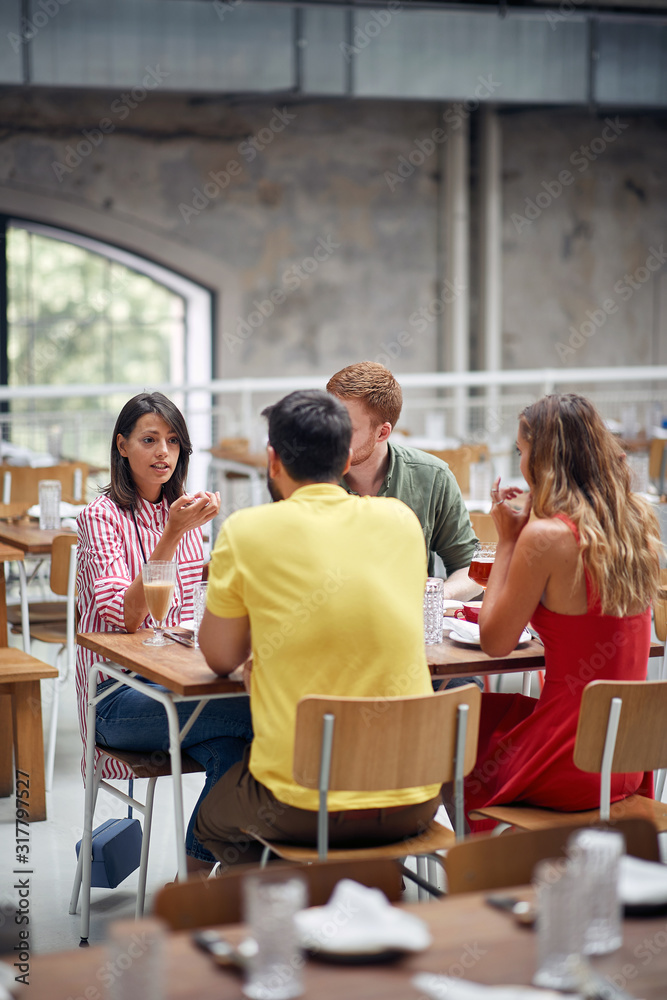 Obraz premium young friends relax in cafe communicating