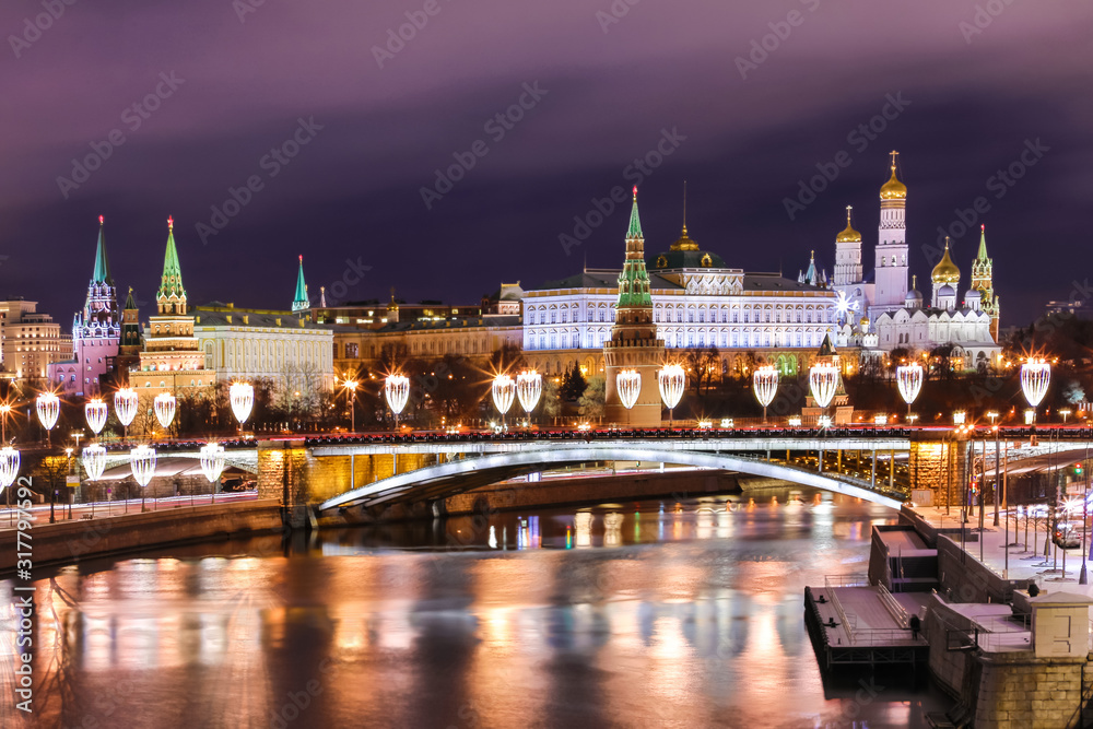 Illuminated Moscow Kremlin and Bolshoy Kamenny Bridge in the night. View from the Patriarshy pedestrian Bridge in Russia. Evening urban landscape in the blue hour