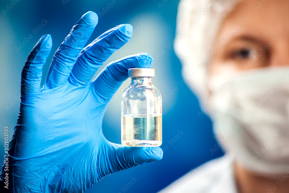 A doctor holding a bottle with vaccine. Medicine and healthcare concept