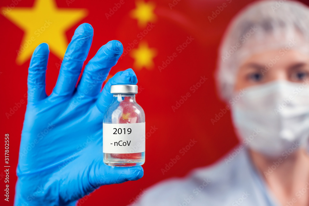 A doctor holding a bottle with vaccine in front of flag of China. Coronavirus, epidemic and healthcare concept A doctor holding a bottle with vaccine in front of flag of China. Coronavirus, epidemic and healthcare concept