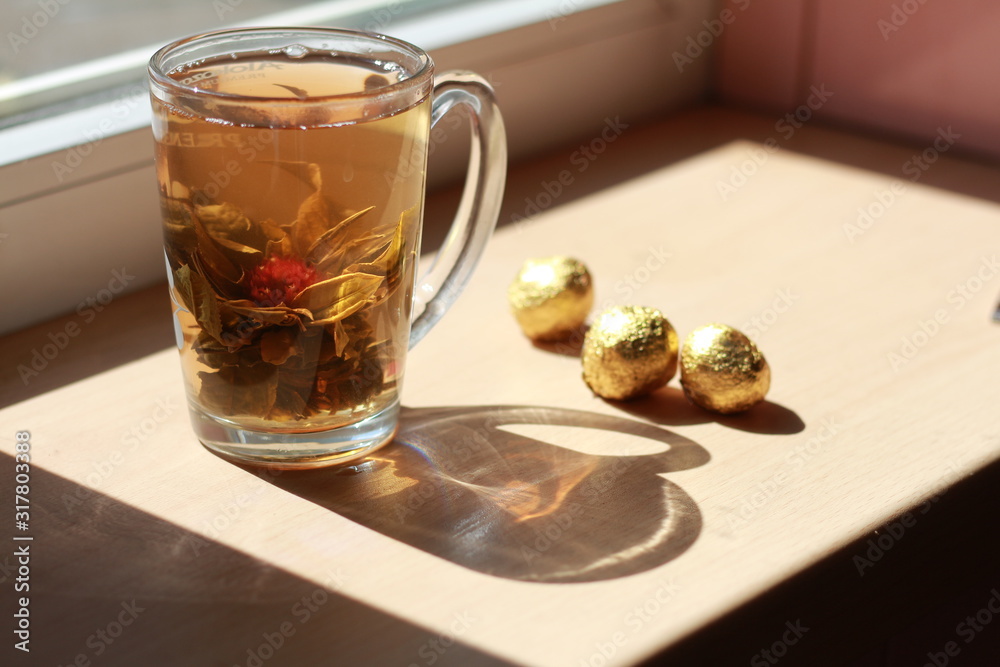 Delicious and fragrant golden tea stands on the windowsill. Delicious and fragrant golden tea stands on the windowsill.