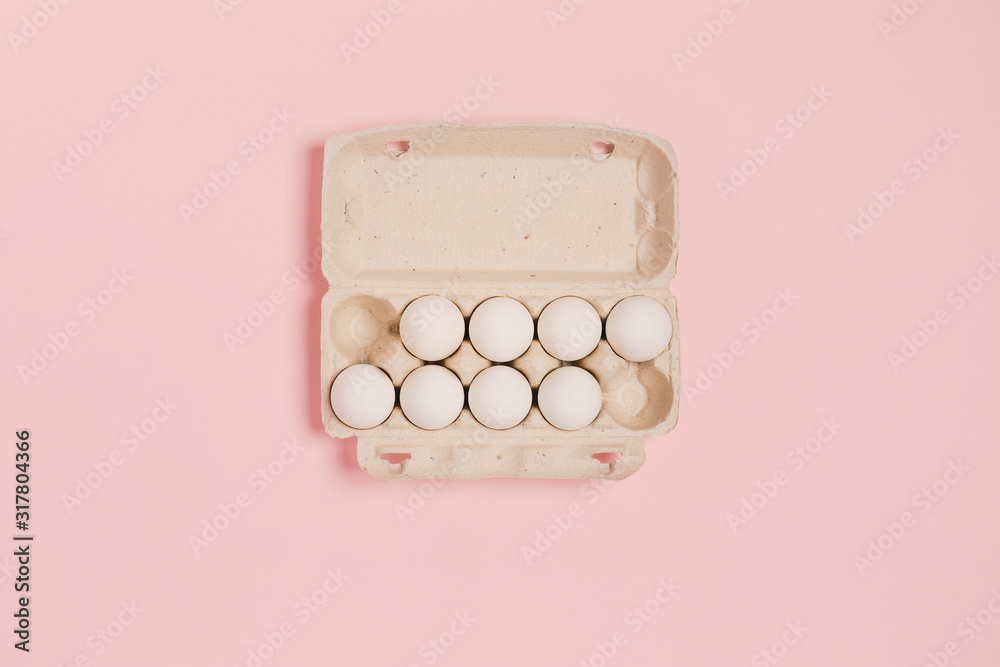 Happy Easter. White eggs in paper packaging on a pink background. Flat lay, top view, copy space. Happy Easter. White eggs in paper packaging on a pink background. Flat lay, top view, copy space.