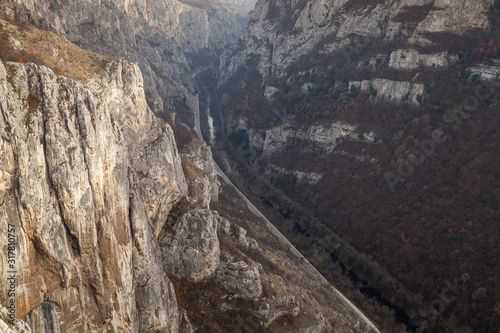 Amazing high angle view of narrow gorge and canyon with sunlit  steep  rocky cliffs raising above river  road and railroad