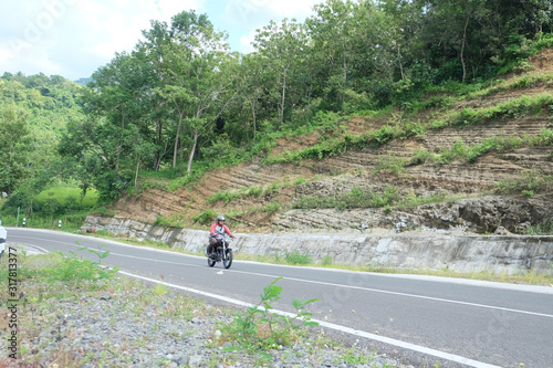 Man riding a classic motorcycle on highway of mountain