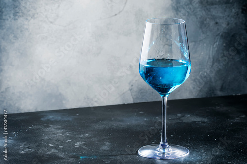 Exotic blue wine, trendy non-classical drink in wine glass on gray background