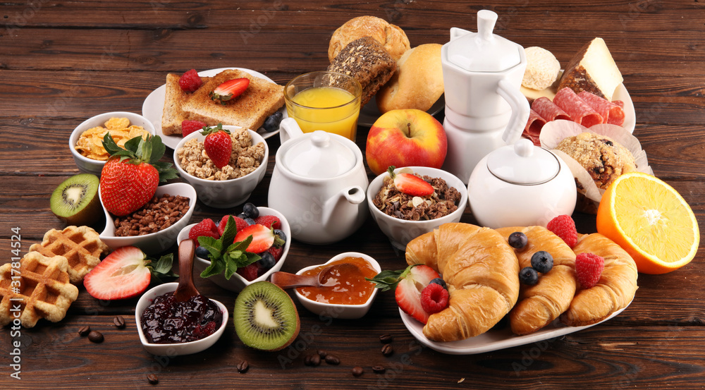 Breakfast served with coffee, orange juice, croissants, cereals and fruits. Balanced diet. Continental breakfast with granola and fruits