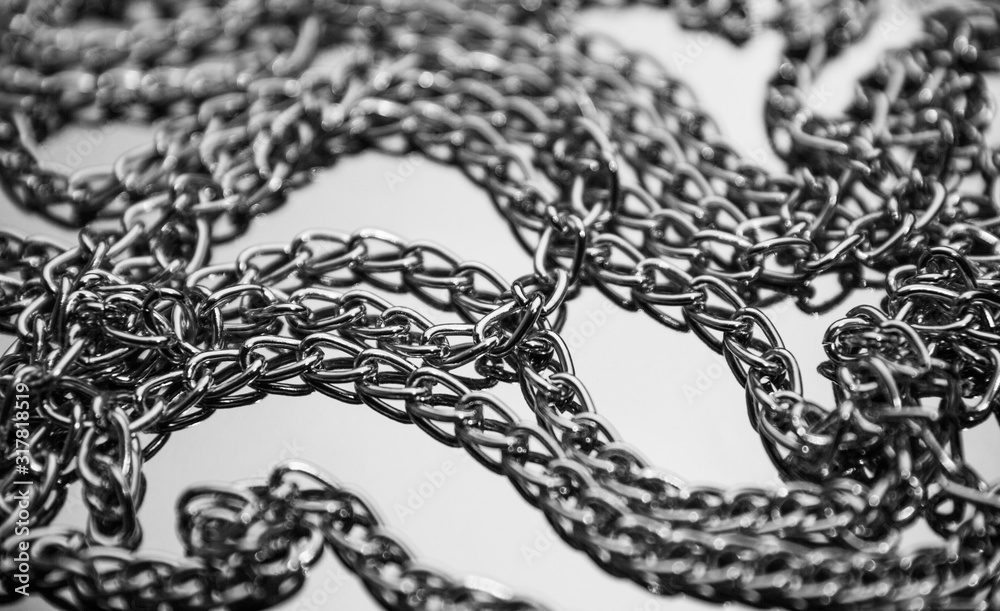 Obraz premium Shiny matallic chains on reflective surface