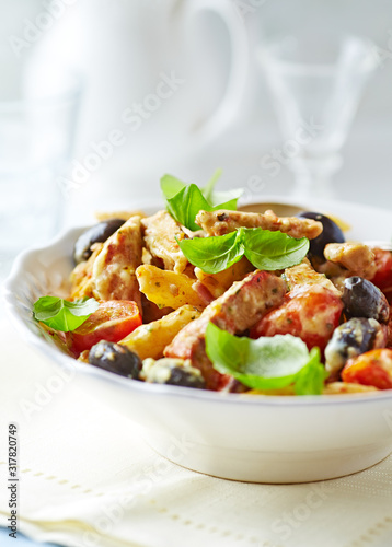 Penne pasta with fried pork tenderloin, cherry tomatoes and black olives. Oven baked.