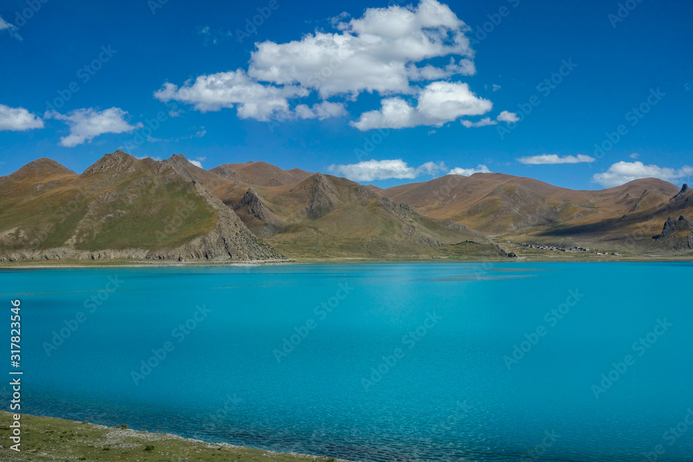 DRONE: Picturesque view of a large turquoise lake in the Tibetan mountains.