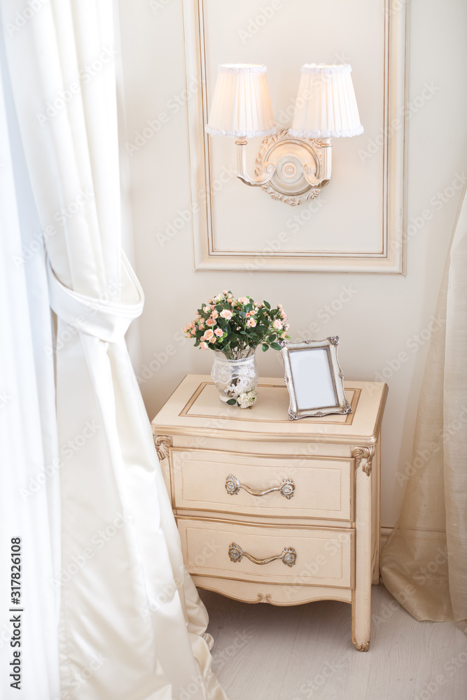 Elegant bedside and sconce. Luxury interior in white colors