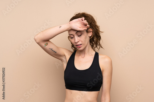 Young sport woman over isolated background with tired expression © luismolinero