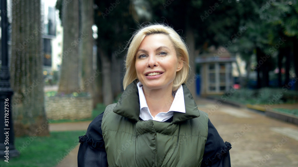 beautiful stylish trendy blond woman walking in a city Park in autumn beautiful stylish trendy blond woman walking in a city Park in autumn