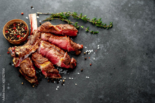 steak - sliced ​​grilled beef tomahawk with spices on a stone background. with copy space for your text