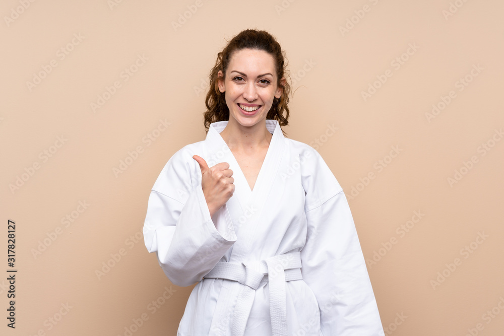 Young woman doing karate with thumbs up because something good has happened Young woman doing karate with thumbs up because something good has happened
