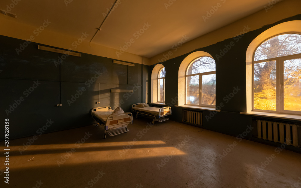 Hospital ward with large semicircular windows and beds, in an abandoned hospital, at night