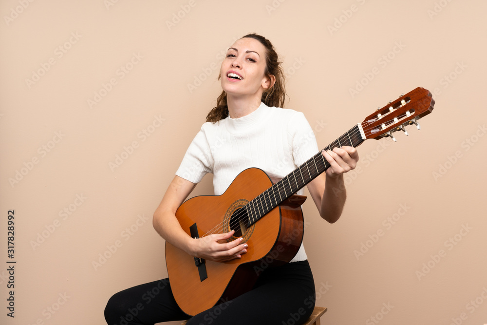 Young woman with guitar over isolated background Young woman with guitar over isolated background