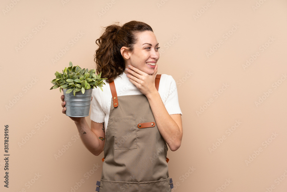 Gardener woman holding a plant thinking an idea and looking side