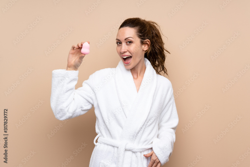 Young woman in a bathrobe over isolated background Young woman in a bathrobe over isolated background