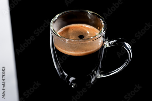 black coffee in a glass transparent cup on a black background