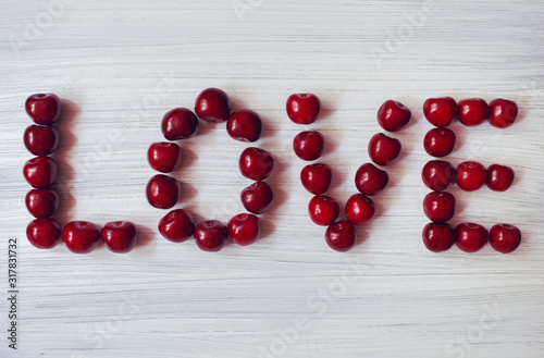 Red cherries on a white background, the inscription love