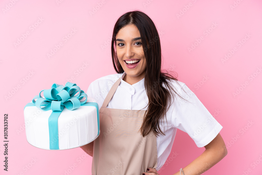 Young woman with a big cake over isolated background Young woman with a big cake over isolated background