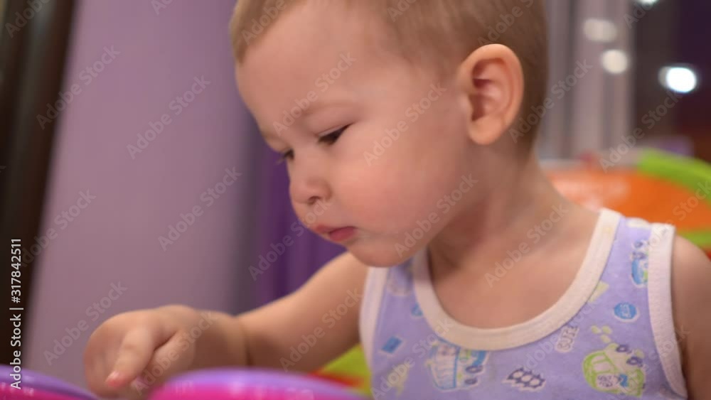The baby learns to play the children's electronic piano. He is in his room. The baby learns to play the children's electronic piano. He is in his room.