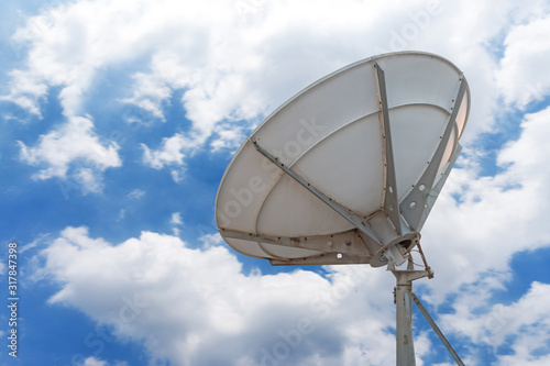 Telecommunications radar parabolic radio antenna as part of global communication technology stations system against sunny sky with sun rays sunbeams