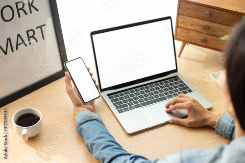 mockup image blank screen computer,cell phone with white background for advertising text,hand man using laptop texting mobile contact business search information on desk in office.marketing and design