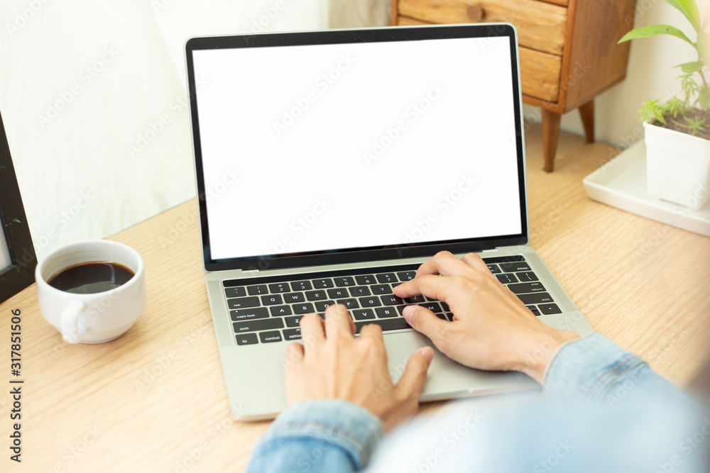 mockup image blank screen computer with blank white background for advertising text,hand man using laptop contact business search information on desk at home office.marketing and creative design mockup image blank screen computer with blank white background for advertising text,hand man using laptop contact business search information on desk at home office.marketing and creative design