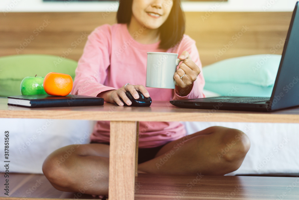Happy woman drinking hot coffee after wake up and using laptop computer in bedroom,Relaxing time Happy woman drinking hot coffee after wake up and using laptop computer in bedroom,Relaxing time