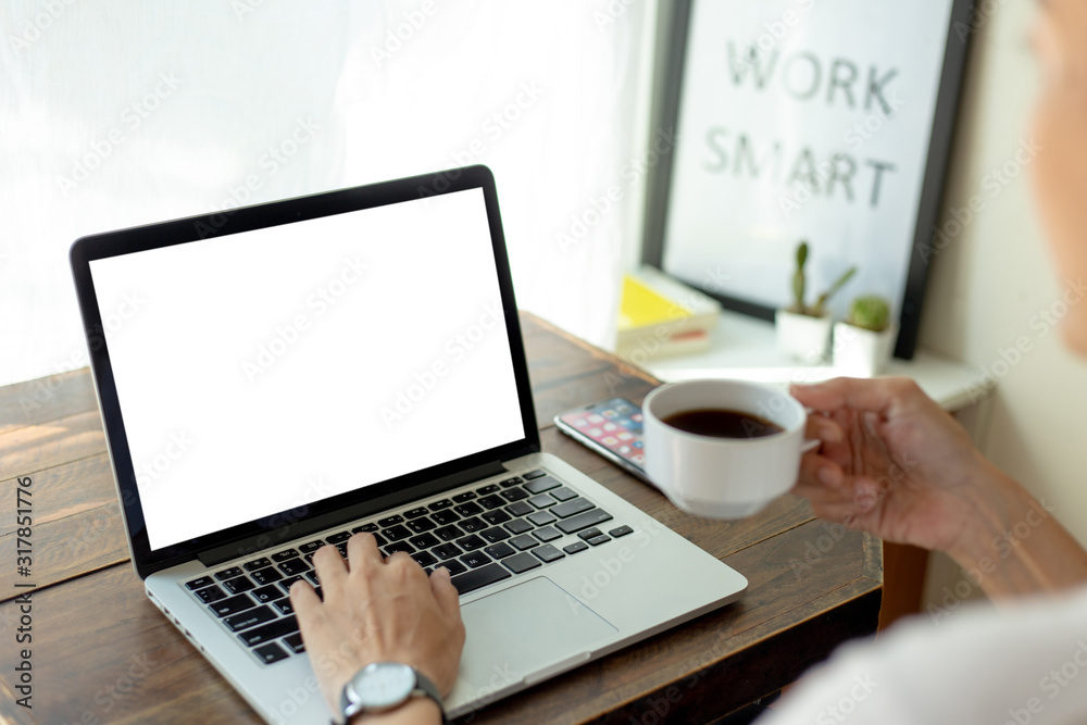 mockup image blank screen computer with blank white background for advertising text,hand man using laptop contact business search information on desk at home office.marketing and creative design mockup image blank screen computer with blank white background for advertising text,hand man using laptop contact business search information on desk at home office.marketing and creative design