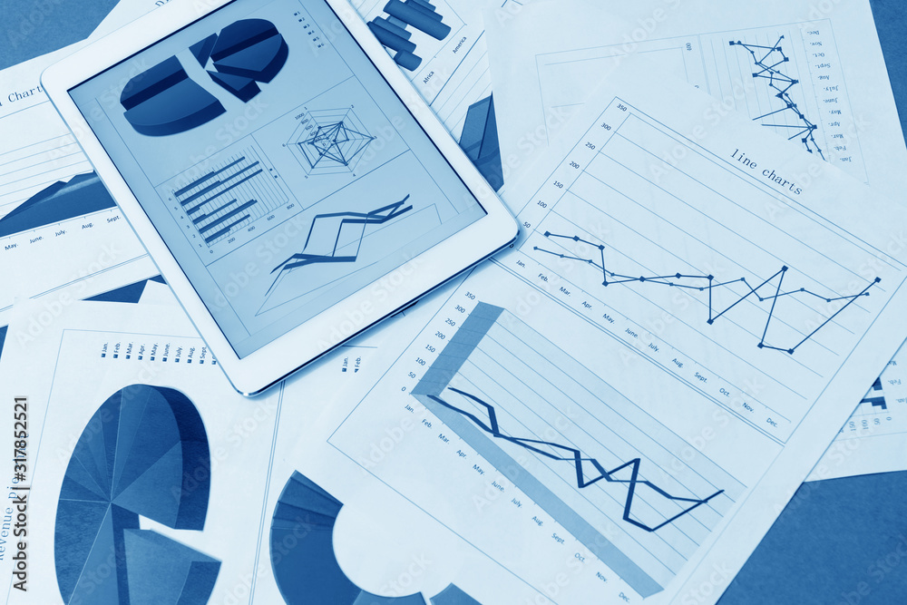 Financial charts on the table with tablet Financial charts on the table with tablet