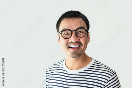 portrait young asian man wear eye glasses Smiling cheerful look thinking position with perfect clean skin posing on white background.fashion people freedom life style concept © panitan