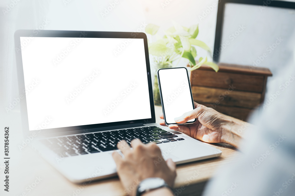 mockup image blank screen computer,cell phone with white background for advertising text,hand man using laptop texting mobile contact business search information on desk in office.marketing,design mockup image blank screen computer,cell phone with white background for advertising text,hand man using laptop texting mobile contact business search information on desk in office.marketing,design