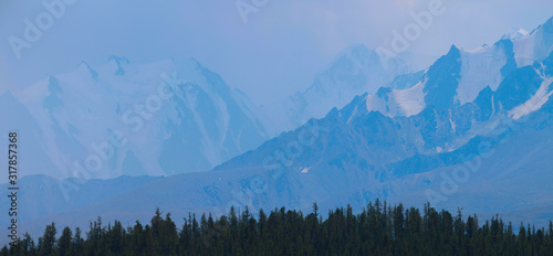 Mountains in a blue haze, snow-capped peaks, panoramic view