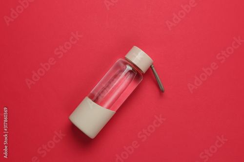 Bottle of water for sports and outdoor activities on red background. Top view