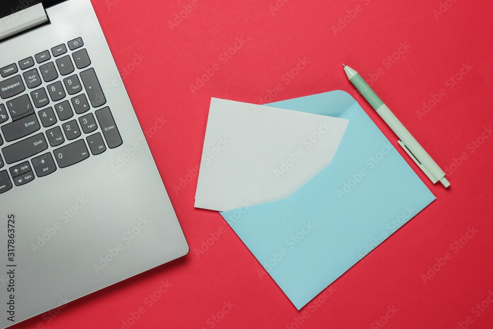 Laptop and envelope with letter on red background. Valentine's day. Top view Laptop and envelope with letter on red background. Valentine's day. Top view