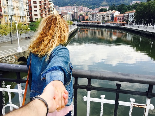 Girl holding her partner's hand with curly blond hair