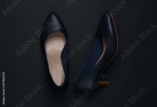 Women's classic high-heeled shoes on a black background. Top view