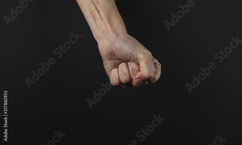 Female fist gesture on a black background