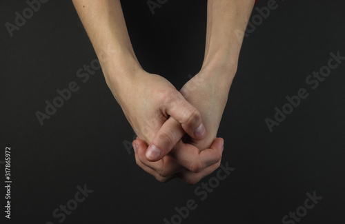 Female hand on a black background. Lock of hands
